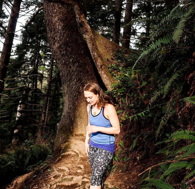 woman in workout clothes smiling in forest