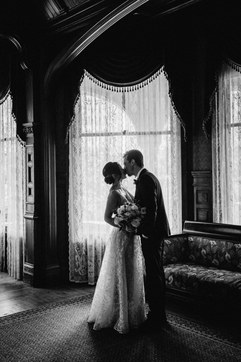 Bride and groom kissing in vintage-style black and white photo
