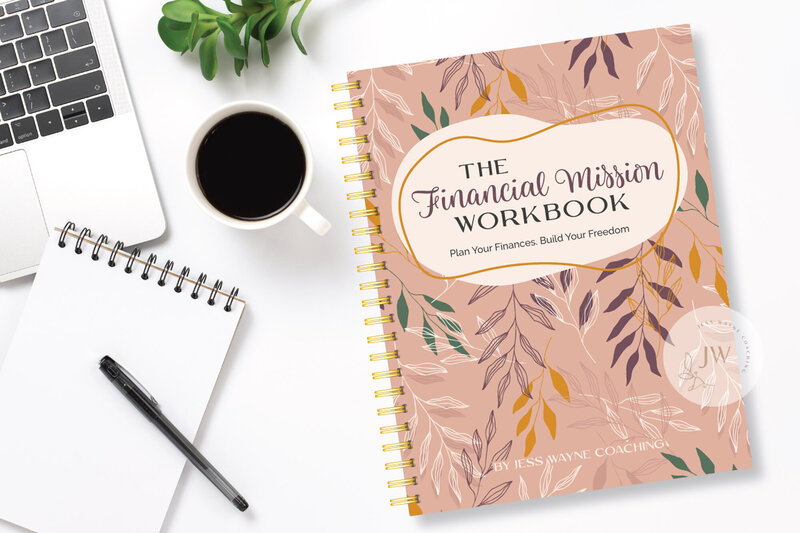 Workbook sitting on a white desk next to a cup of coffee