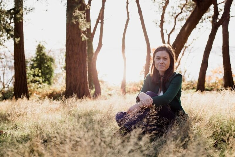 Portrait of Meredith Fay, stress management coach sitting in a field