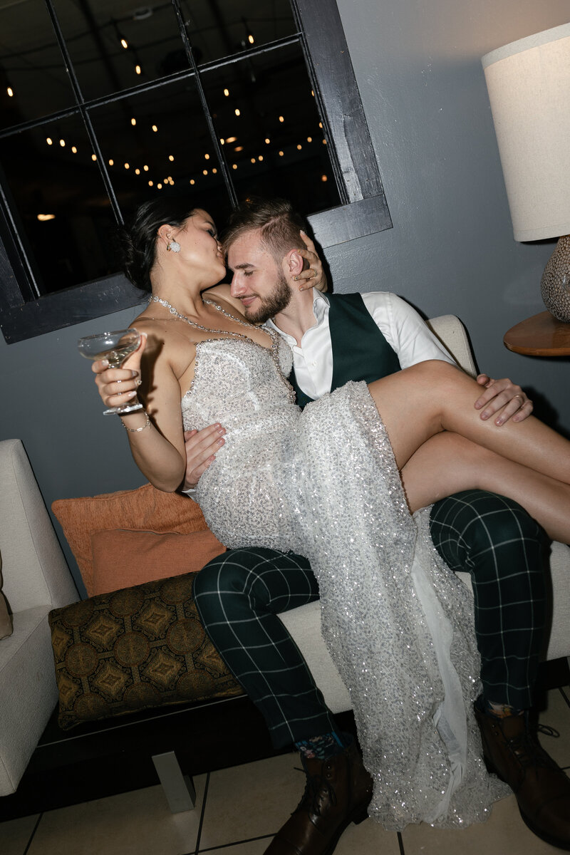 bride in groom at upscale bar with bride on grooms lap with a drink