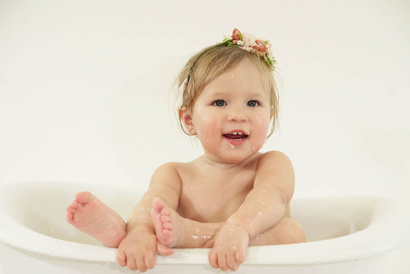 9-month old girl in a mini bathtub for baby photoshoot