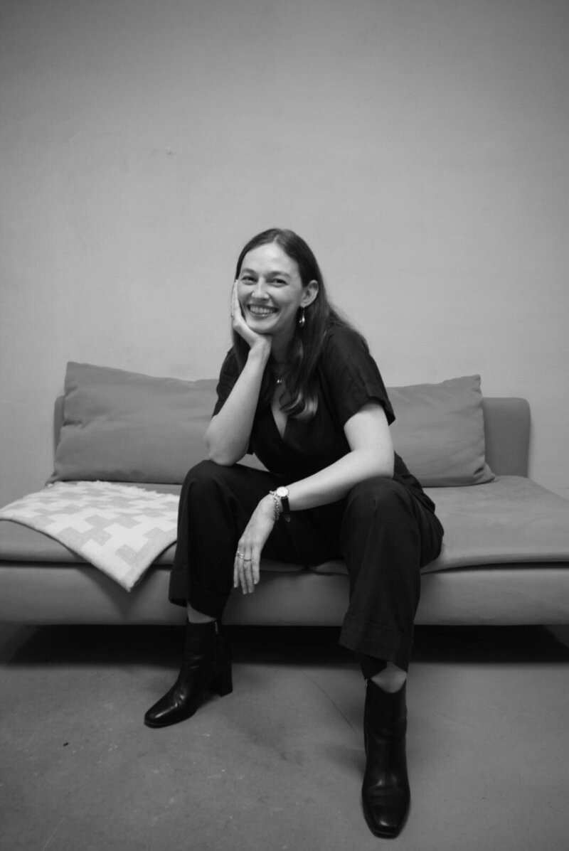 Cora Demary in black shirt with hand on chin