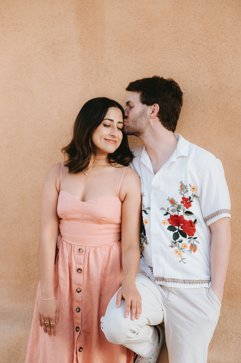man kissing woman's forehead during their engagement session
