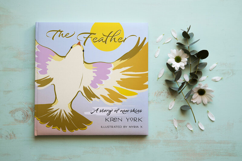 The Feather book beside anemone flowers on a green background