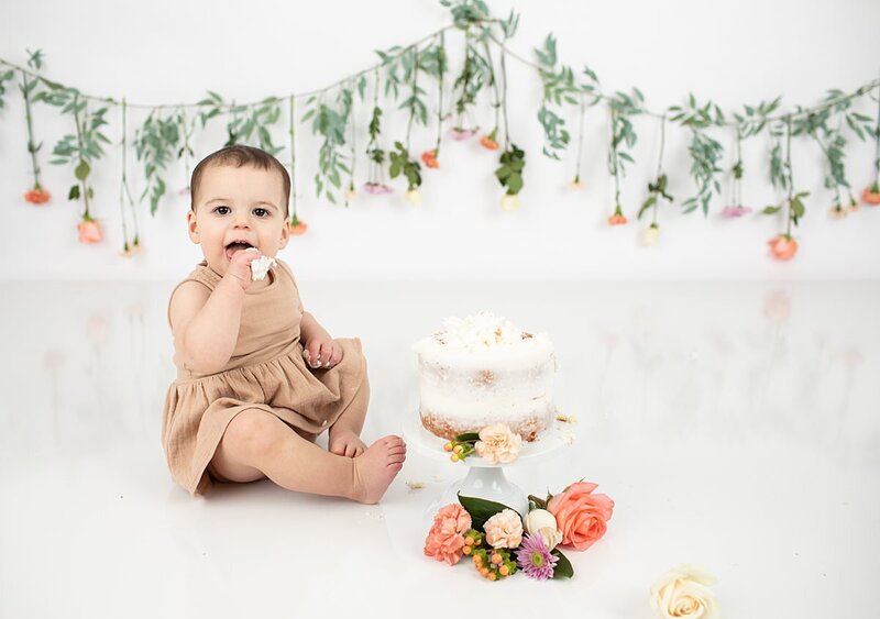 Baby eating cake for first birthday cakesmash by Maryland Portrait Photographer