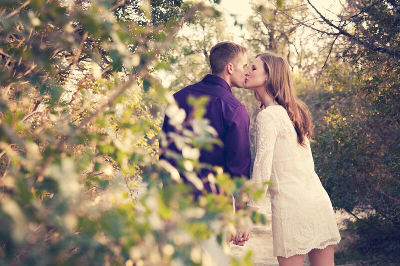 engaged couple kissing in a park in Winter Park, FL during engagement photo session with Melissa Vinsik Photography