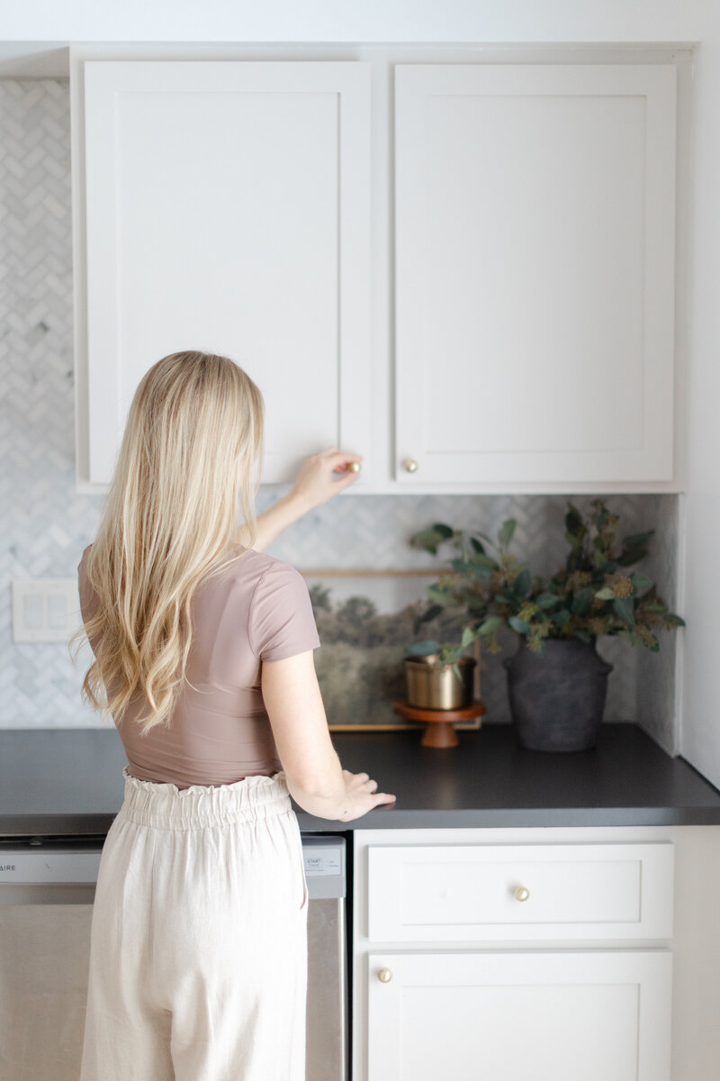 Sammie standing next to kitchen cabinets