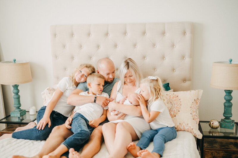 Family of 6 with newborn baby on bed taken by Ann Arbor Newborn Photographer