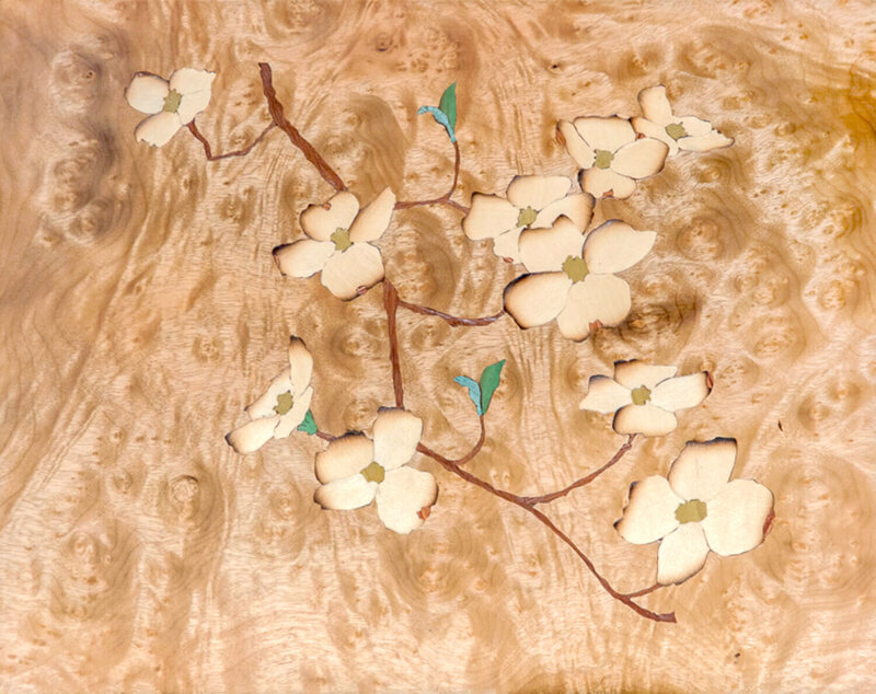 A sand shaded marquetry picture with Virginia dogwoods on a burl background  | Heller and Heller Furniture