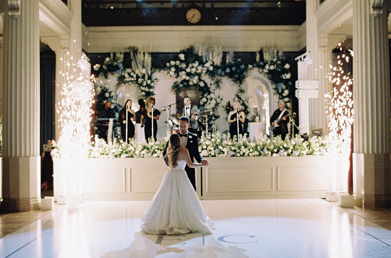 Bride and groom kissing while bridal party cheers around them