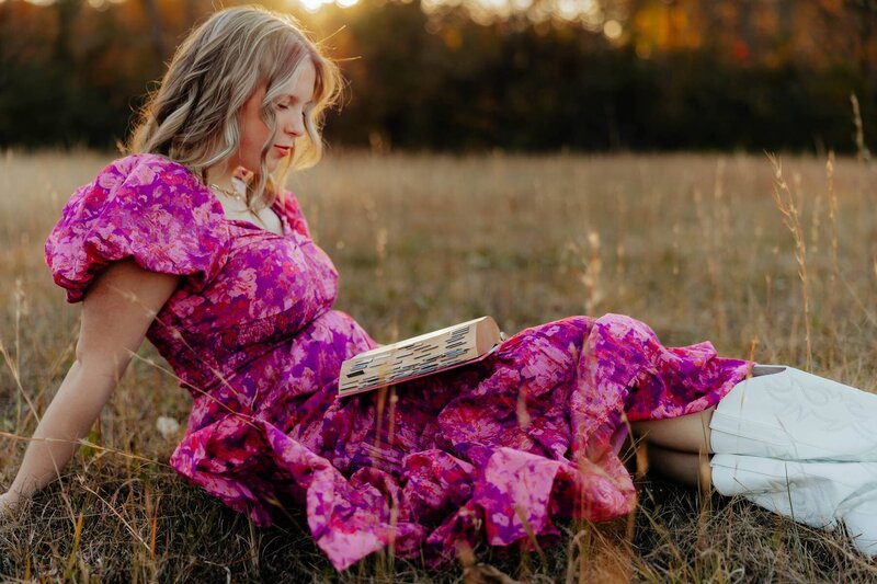 young girl sitting in field for self portraits with bible in her lap