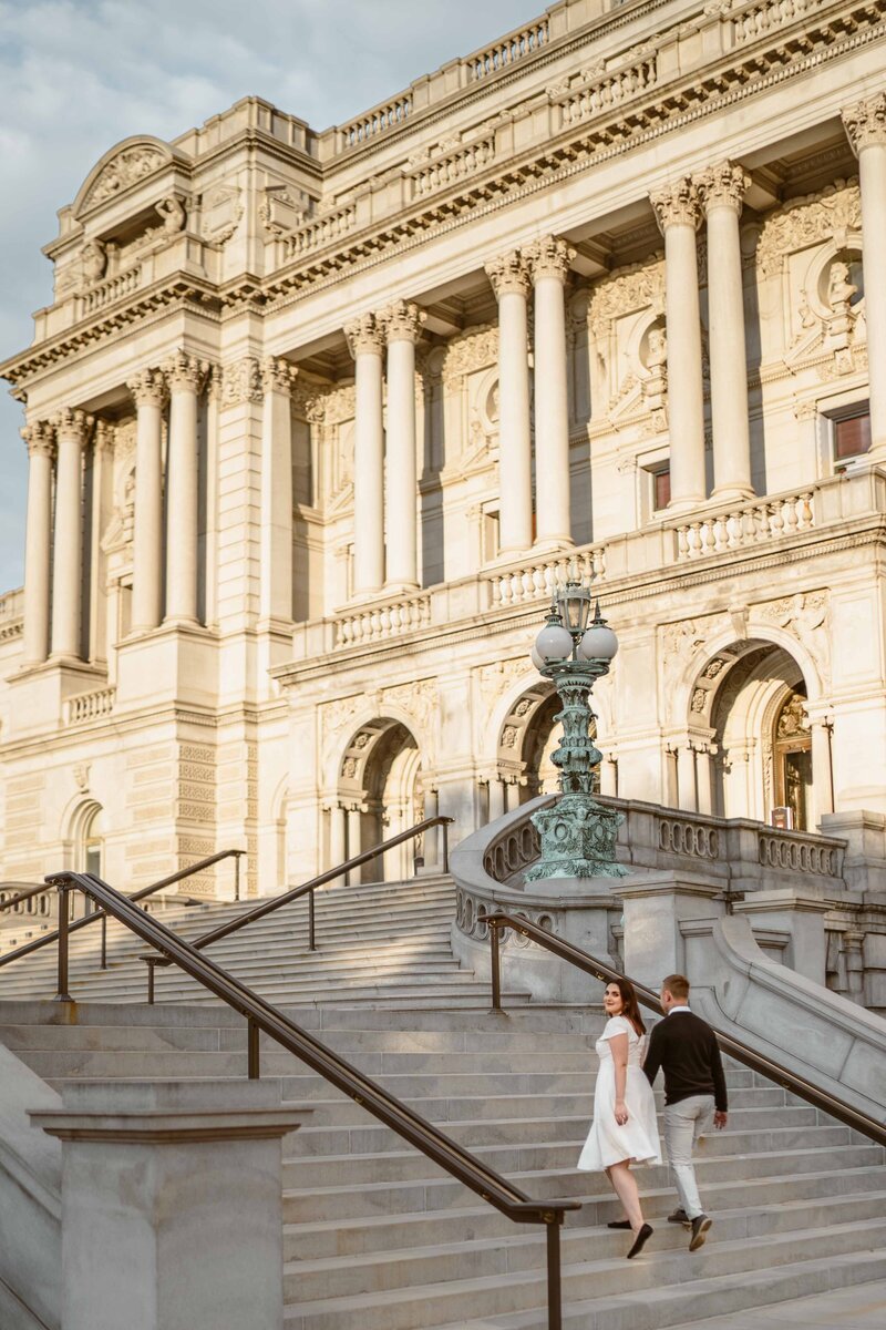 bride and groom walking on the stairs  in front of library of congress sunset time