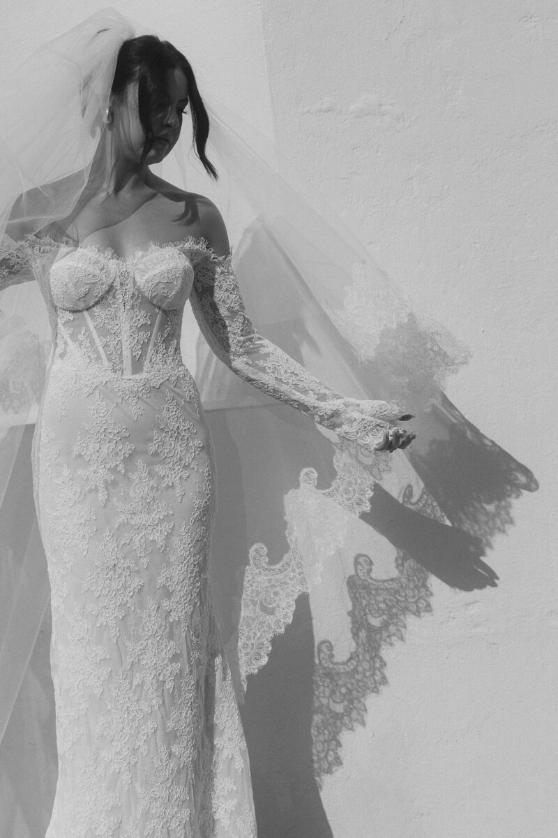 detail photo of brides lace veil casting shadows on the wall