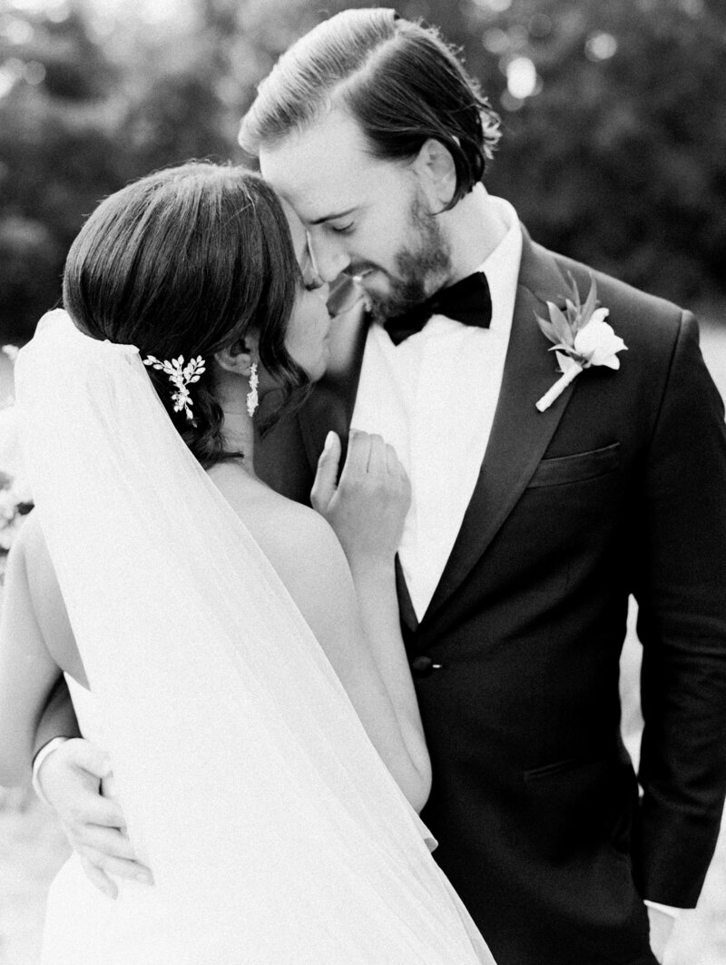 black and white image of bride and groom embracing nose-to-nose