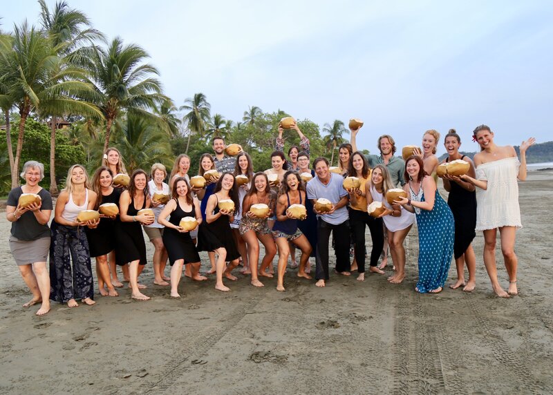Students enjoy Coconuts at graduation for the 200 Hour YTT Program on the beach in paradise