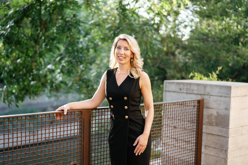 Amy Lane dressed in black leaning on a fence