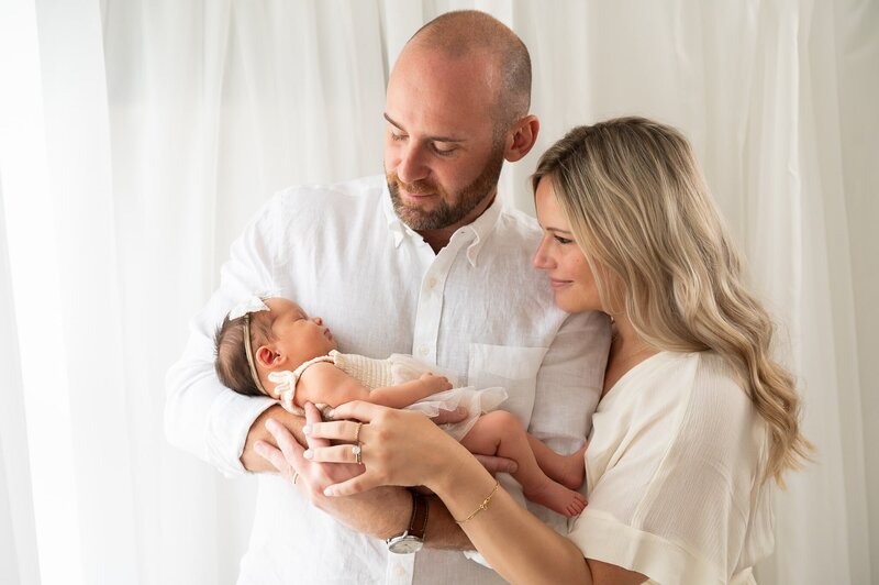 New mom and dad holding theire baby during a photo shoot