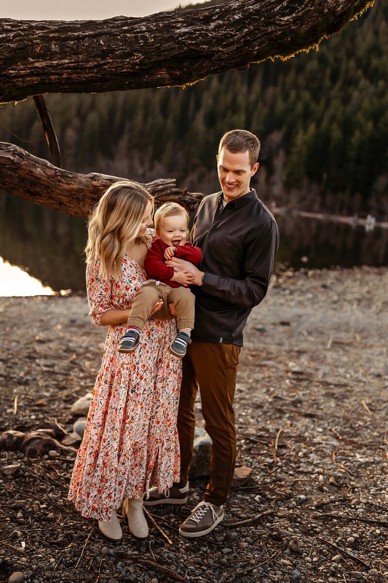 Join Everest Portraits for a relaxed family photo session on the serene shores of a Seattle lake, where every laugh and tender touch is immortalized against a stunning mountain backdrop.