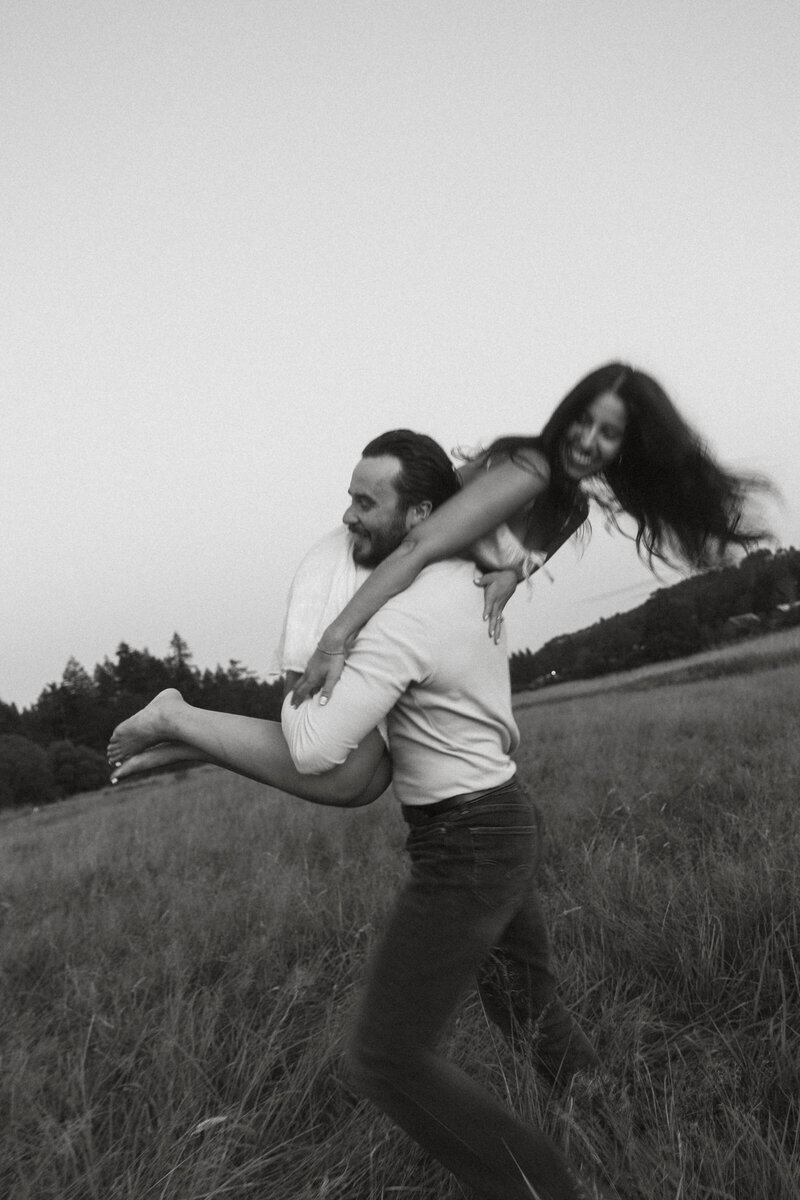 Playful moment between a couple in a field during golden hour portrait session on Vancouver Island