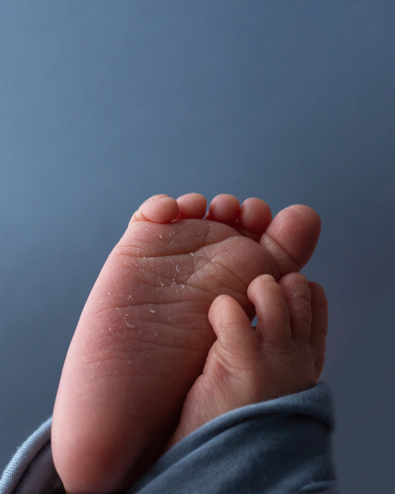 Newborn baby toes wrapped in blue wrap.