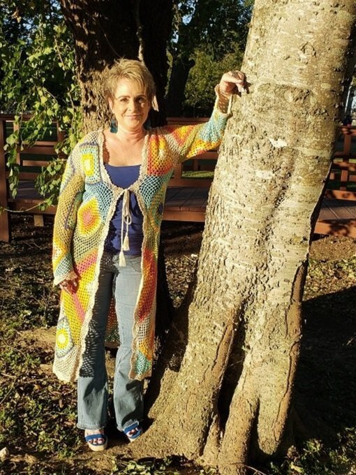 Jennifer Slaugher shoulders up in the foreground with an abstract painting in the background