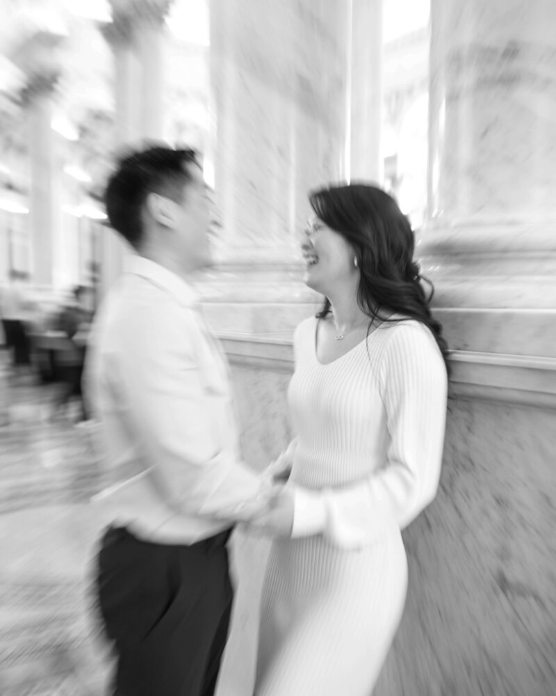 couple laughing together in the Library of Congress during their engagement session