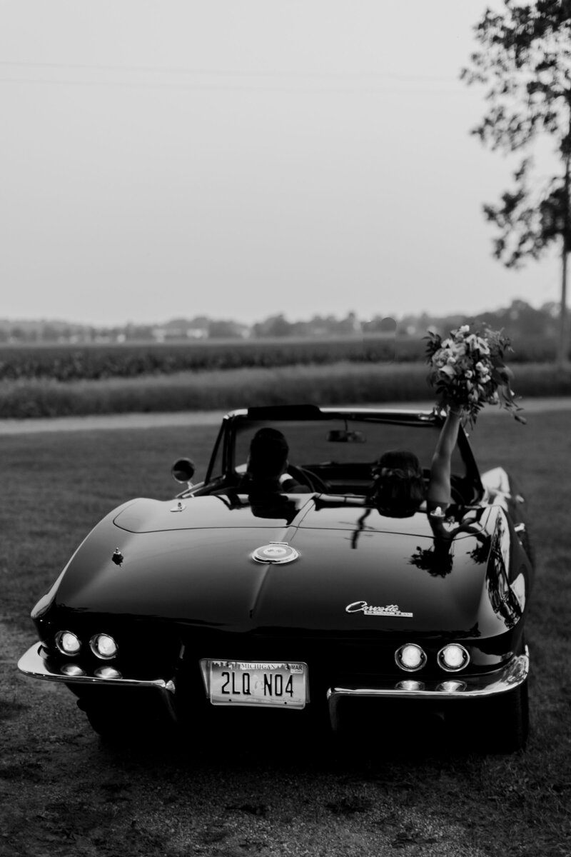 bride and groom ride away in their getaway car from their Lansing Michigan wedding, photography by Cynthia Mae Photography Grand Rapids Wedding Photographer