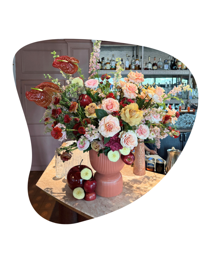 Custom floral arrangement designed by The Floral Eclectic featuring seasonal blooms in a boutique hotel lobby. Perfect for weekly floral delivery in Dallas and Fort Worth to elevate first impressions and client experiences.