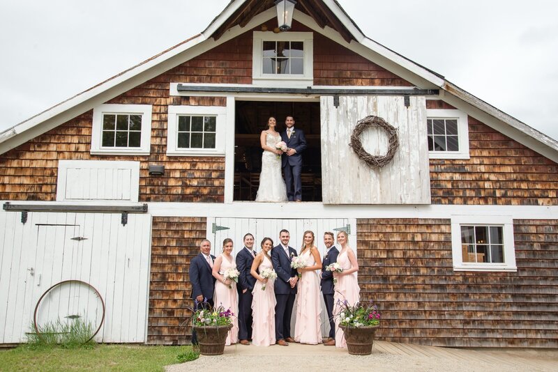 bridal party photo standing outside of a barn