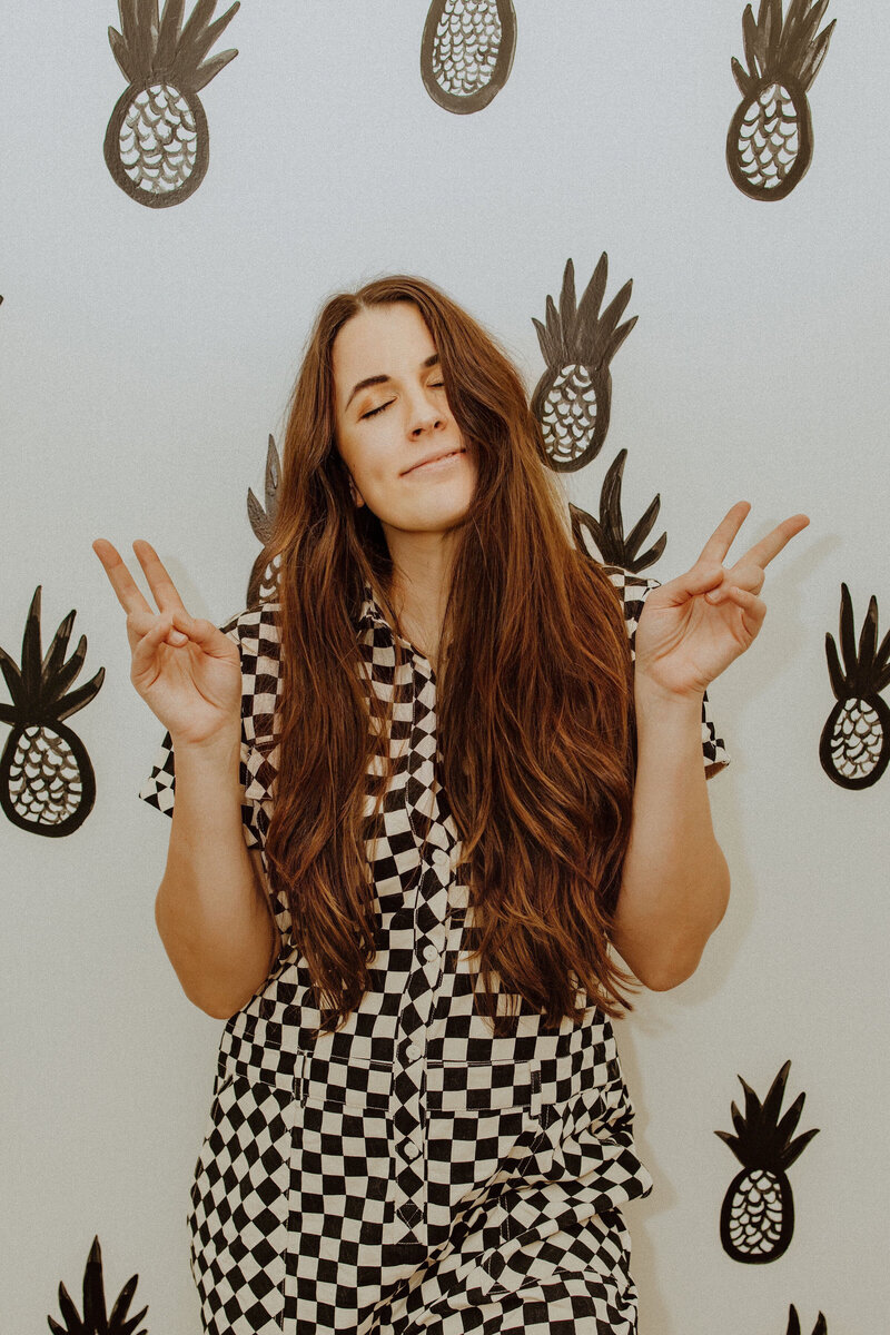 woman in checker set making peace signs with her hands