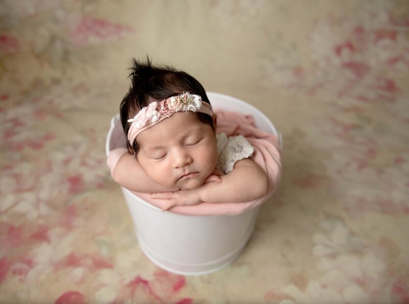 girl newborn in bucket pink