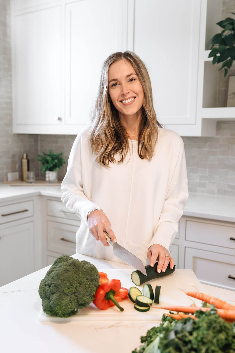Erica Taylor, holistic nutritionist and mom, preparing fresh vegetables as part of a realistic wellness routine for moms
