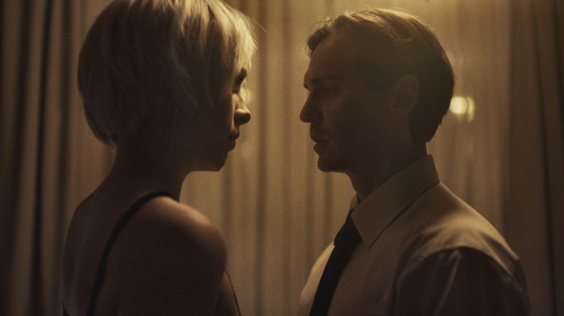 A dramatic stare-down between rivals, framed in a tight, cinematic shot.