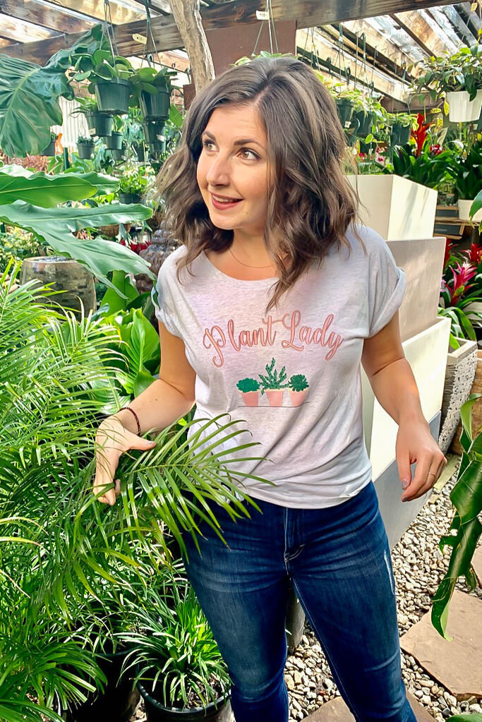 Maria stands in a greenhouse in awe of plants