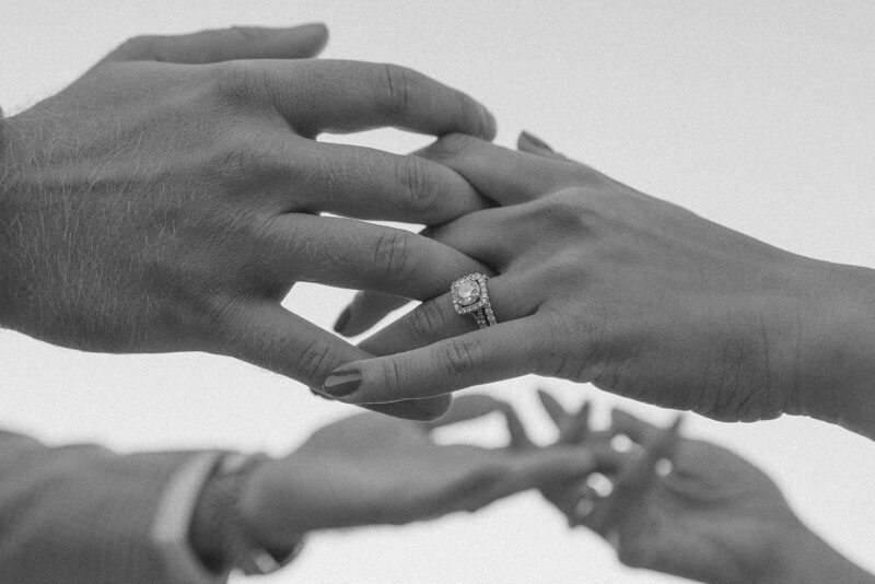 Couple holding hands with engagement ring