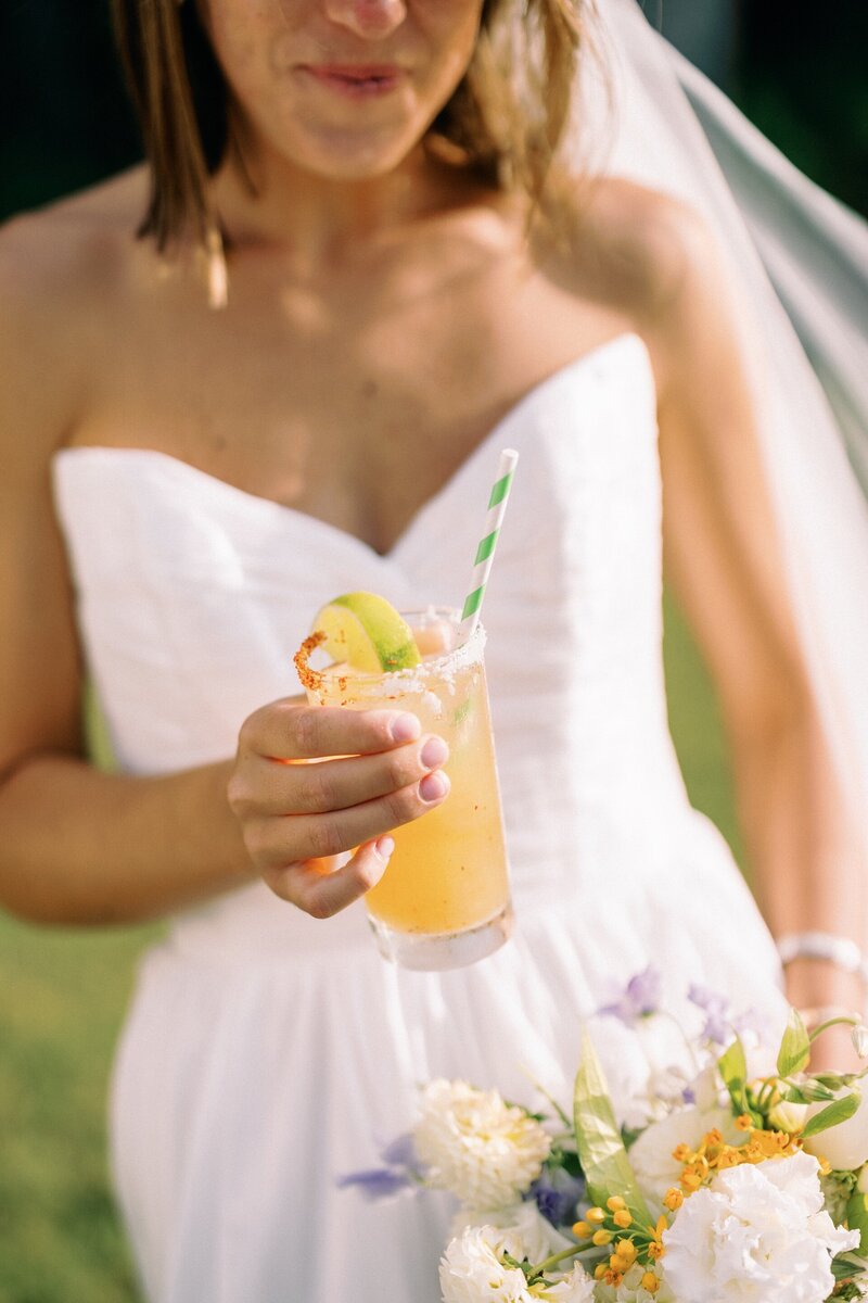 a bride holding a bright orange cocktail