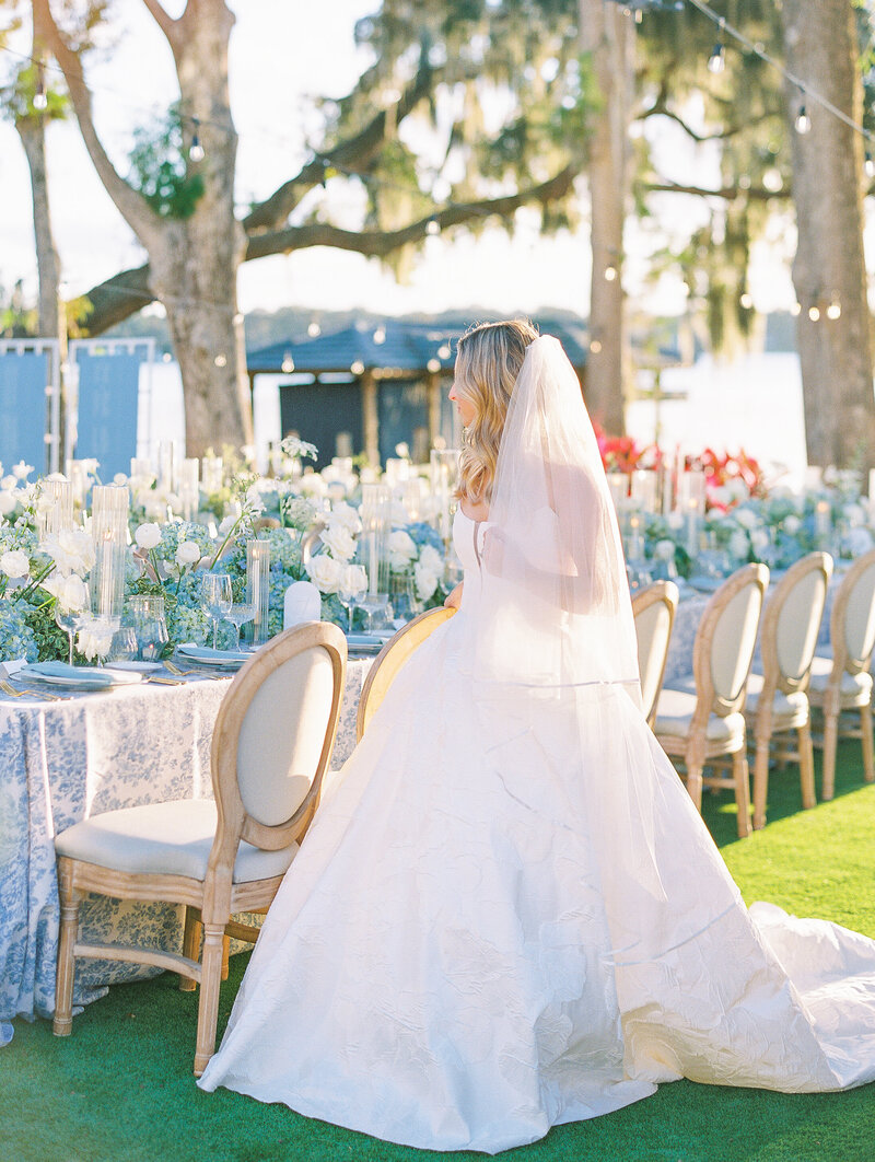 Bride Admires Flowers at Luxury Destination Wedding at Chateau de Courtomer