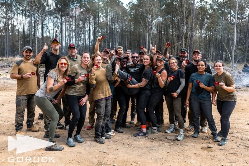 Joe Baker Fitness coach and The Bakery athletes celebrating completion of GORUCK BOLTS Bragg event with team photo.