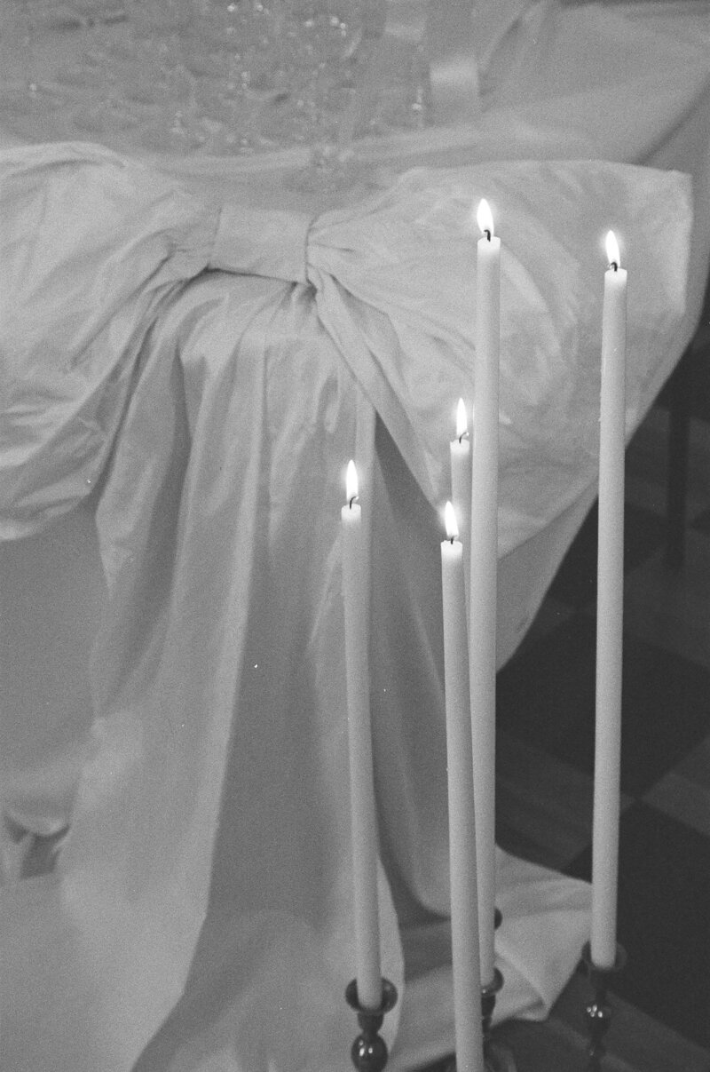 Bride draped in her veil, holding her boquet of white roses