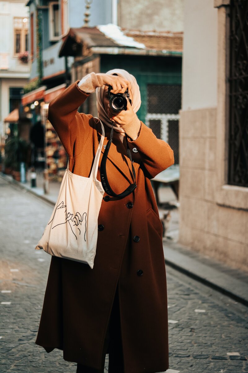 woman taking a photo on a street