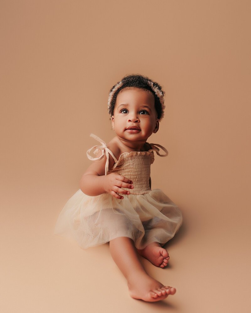 One-year-old clapping hands with joy during milestone photo session