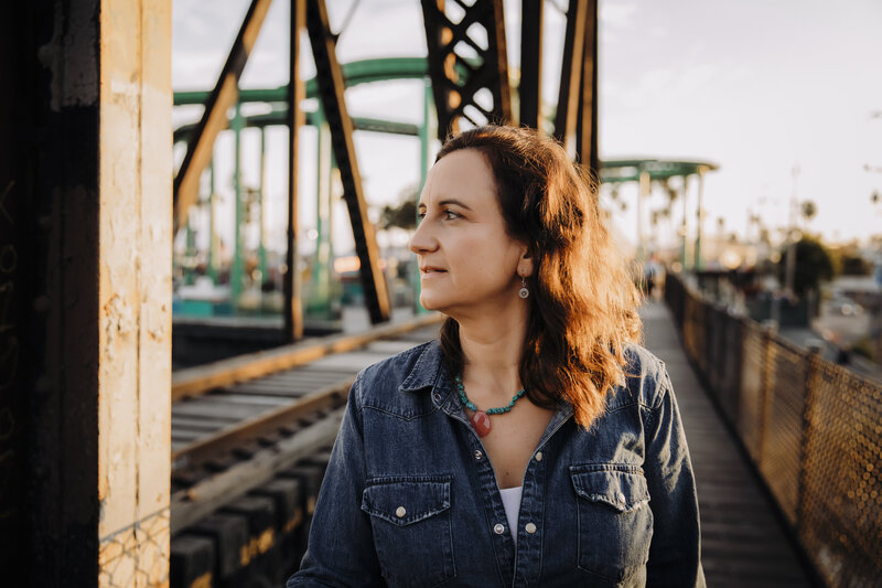 Yvonne, Oʻahu midwife and founder of Wunderbirth, standing on a boardwalk during sunset