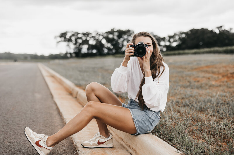 Photographer taking picture in front of white wall