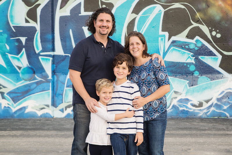 st-louis-mini-sessions-family-of-four-standing-in-front-of-graffiti-wall-in-downtown-st-louis
