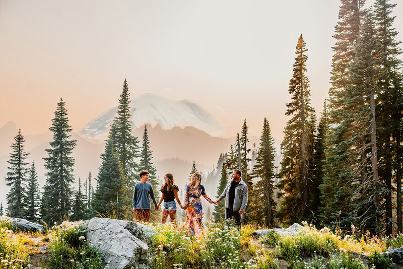 a family with older children in a line in front of Mt Rainier next to Tipsoo lake