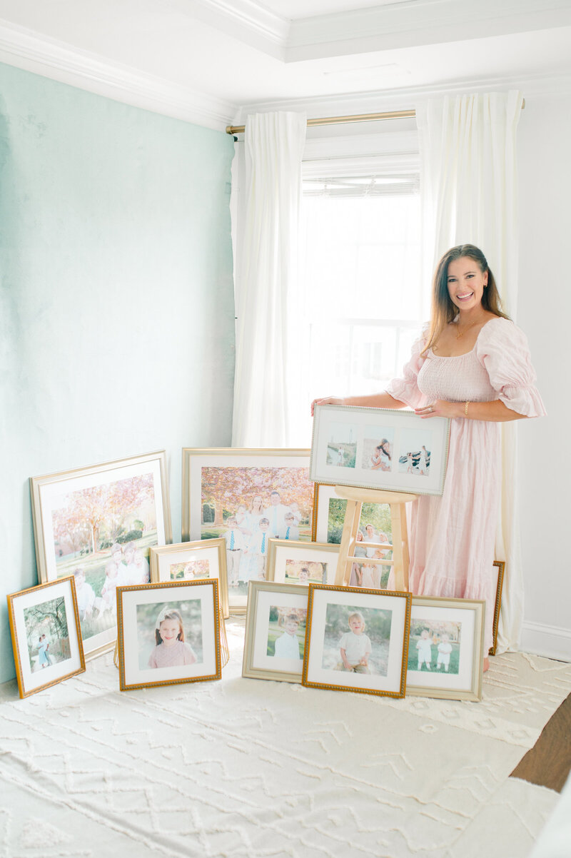 Jessica Jeremiah Photography holding a large collection of framed prints