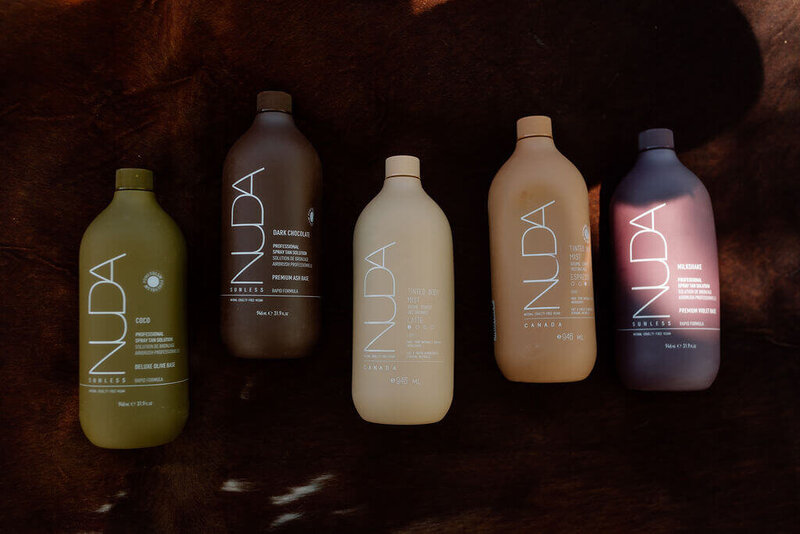 Nuda sunless tanning solution bottles used for group spray tan appointments at Boho Glow Studio in Mankato, MN.