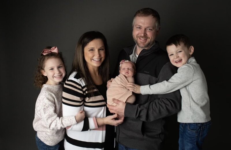Family of five with newborn in studio for photoshoot.
