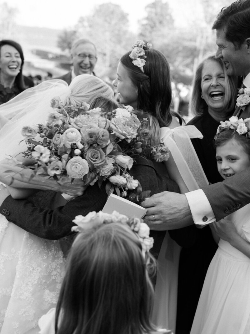 a black and white image of a bride and her father embracing one another